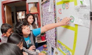 group of students adding items to bulletin board